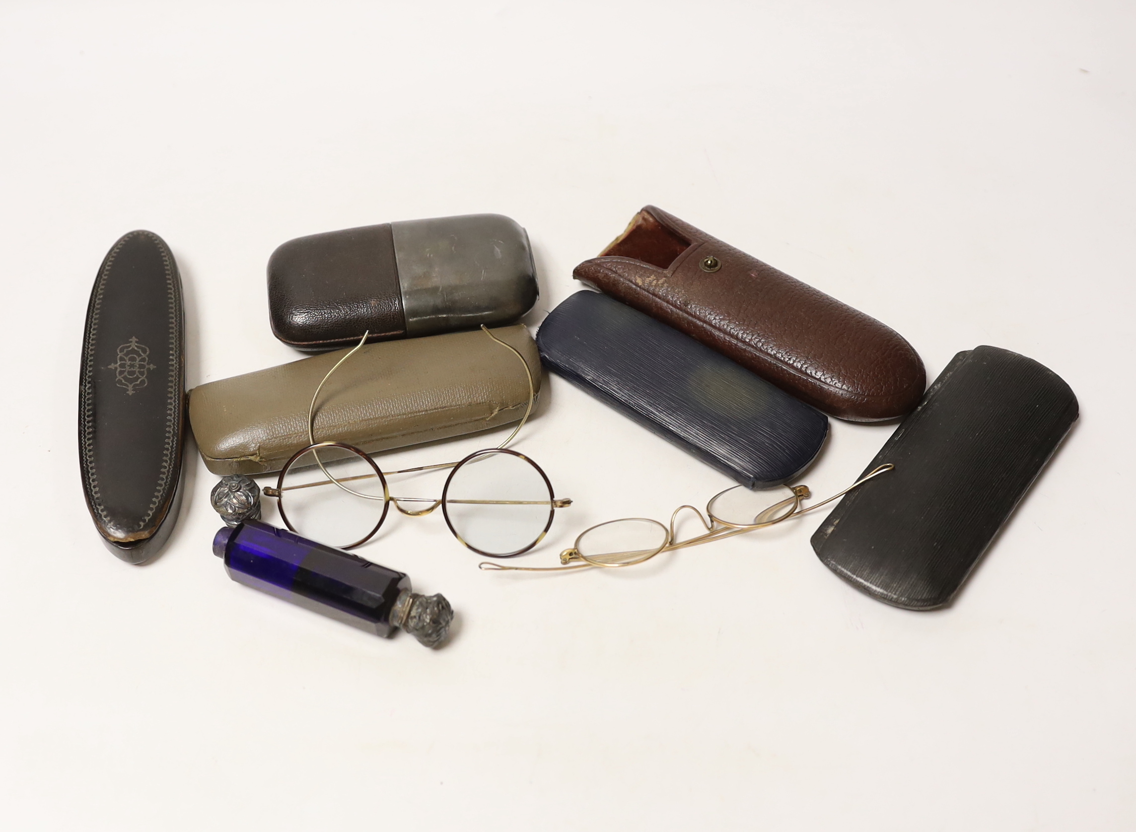 Assorted spectacles in cases, scent bottle and flask.